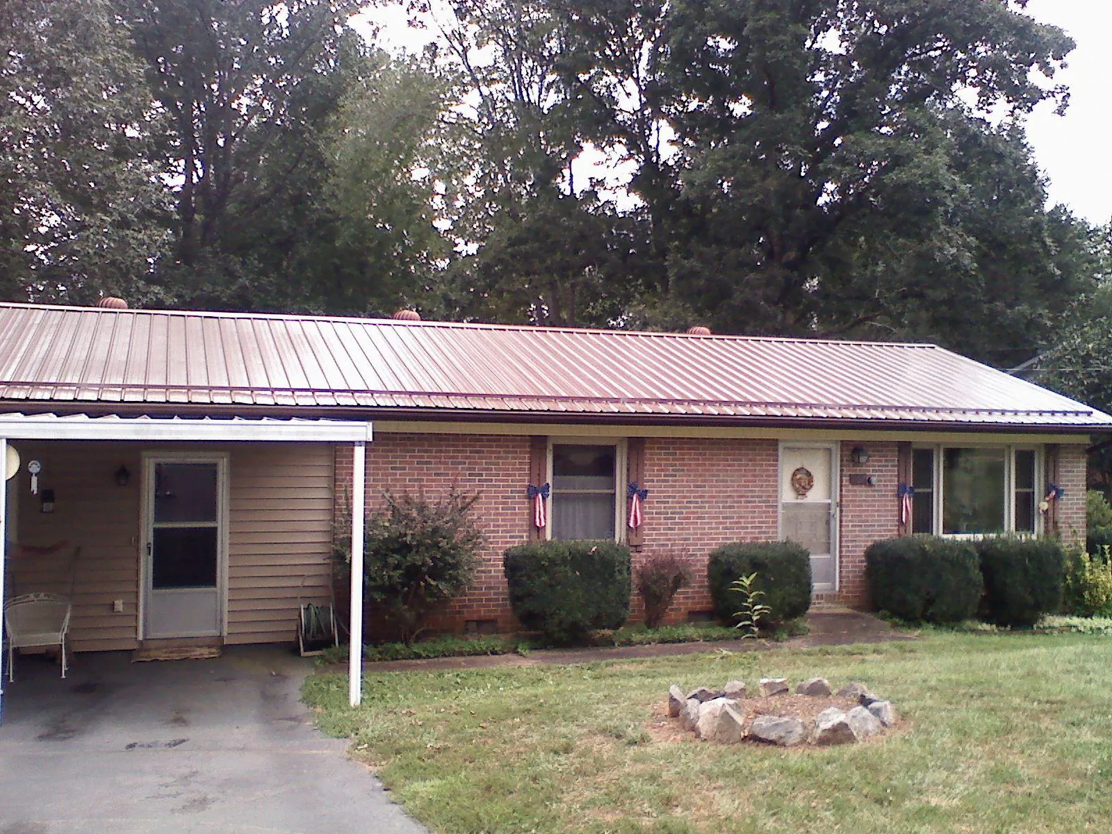 Bronze metal roof and carport on a brick ranch home — Roof Repair work by our crew in Macon